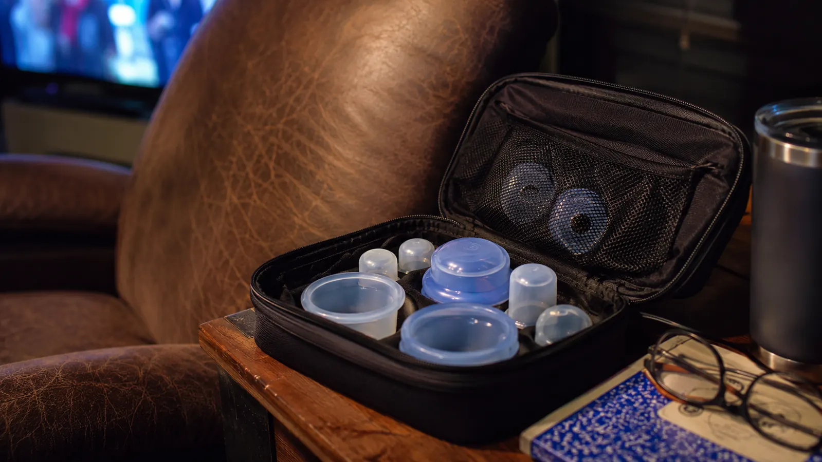Small bag of silicone cupping cups of various sizes sitting open on a nightstand next to a recliner