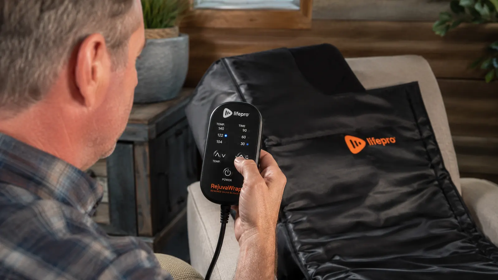 Hand setting the temperature dial on the Lifepro RejuvaWrap infrared sauna blanket control unit
