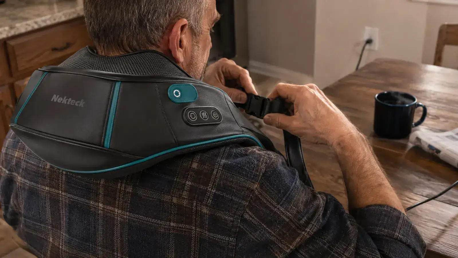 Close-up of hands adjusting the strap on a shiatsu neck massager and repositioning the kneading nodes at the base of the skull